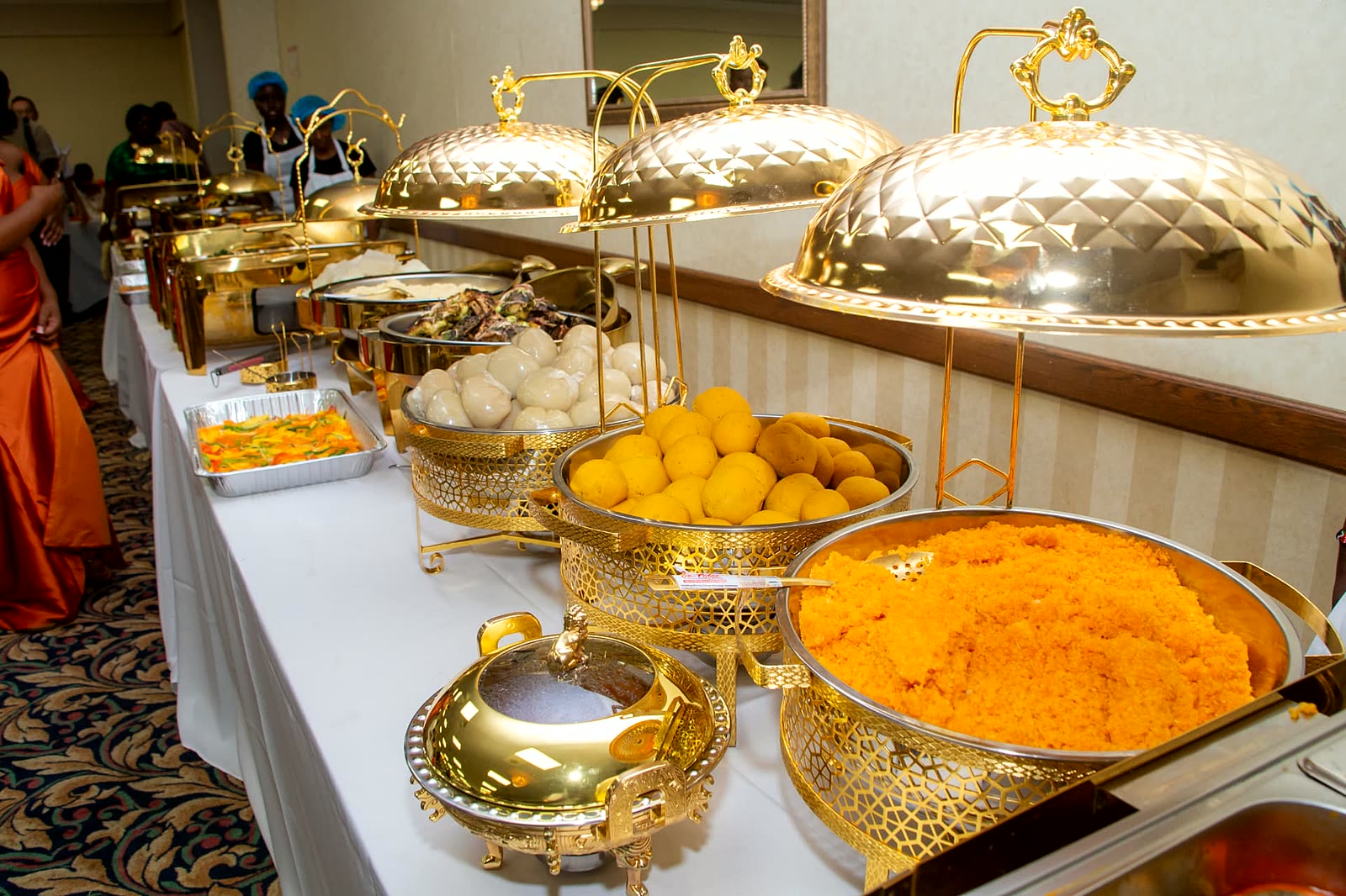 Golden domed chafing dishes with matoke, posho and carrot rice at an event catered in Toronto